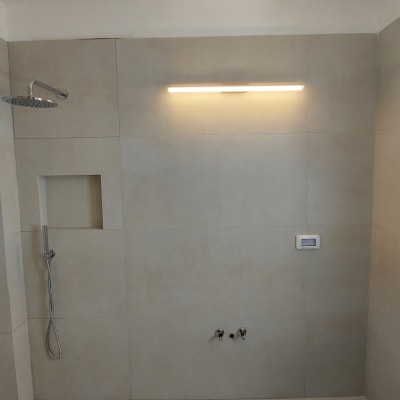 חדר אמבטיה עם מקלחת חדשה וקיר אריחים