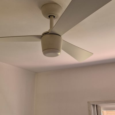 מאוורר תקרה לבן מותקן בחדר עם חלון