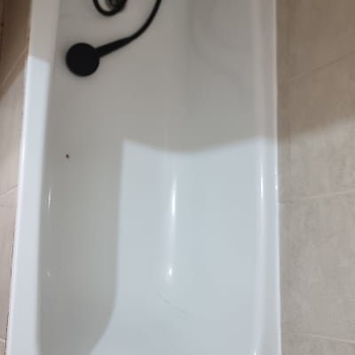 אמבטיה לבנה עם צינור מקלחת שחור