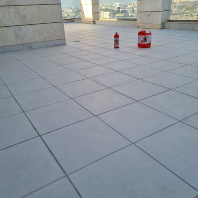 רצפה מרוצפת עם חומרי ניקוי ושיפוץ על המרפסת