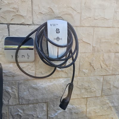 מטען חשמלי לרכב עם כבל תלוי על קיר