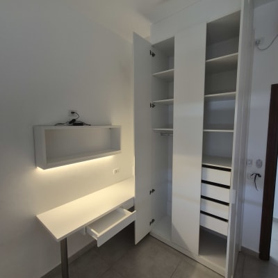 ארון בגדים ושולחן עבודה בחדר מואר