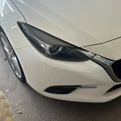 חזית רכב לבן עם פנס קדמי מבריק