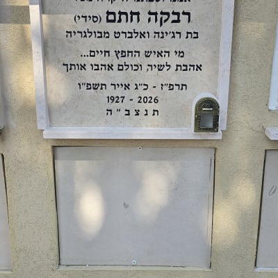 מצבה עם כיתוב בעברית על קיר חיצוני
