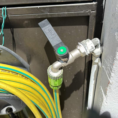 ברז מתכת עם צינור ירוק וצהוב מחובר