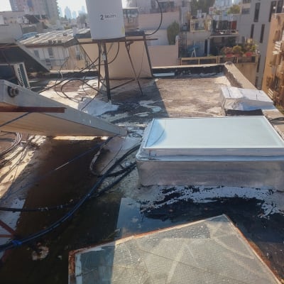 גג עם חומרי איטום, דלי וצינורות