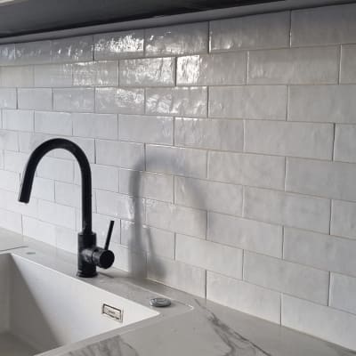 כיור וברז במטבח עם אריחי קיר לבנים