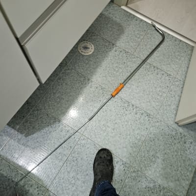 נחשול אינסטלציה על רצפת אריחים עם רגליים