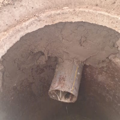 צינור ביוב עם מים זורמים לתוך בור