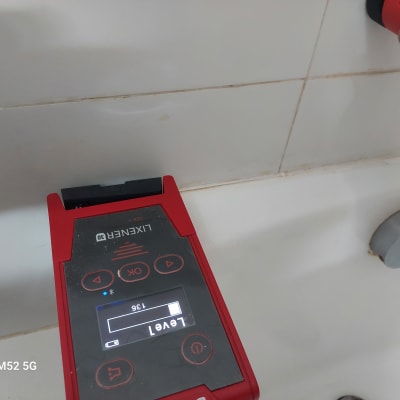 מד לייזר אדום על קיר אריחים לבן