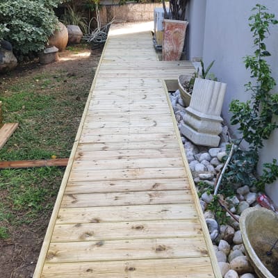 שביל עץ בגינה עם לוחות עץ מונחים בצד