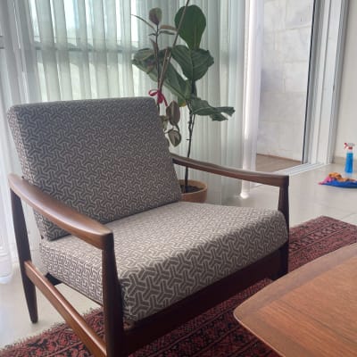 כיסא מרופד עם דוגמת גיאומטרית על שטיח אדום