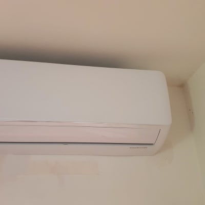 מזגן קיר לבן מותקן על קיר פנימי