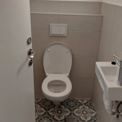 אסלה לבנה וכיור קטן בחדר שירותים