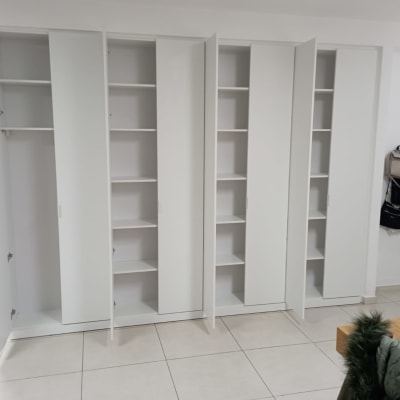 ארונות לבנים עם דלתות פתוחות ומדפים פנימיים