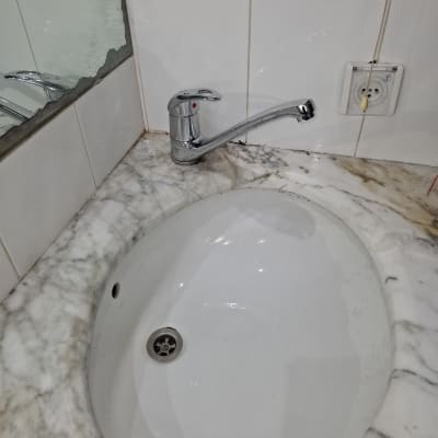 ברז כרום מותקן על כיור שיש לבן