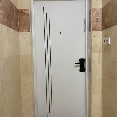 דלת לבנה עם ידית שחורה ועיטורים אנכיים