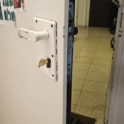 דלת פתוחה עם מנעול ובריחים גלויים