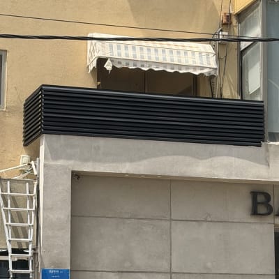 בניין עם חיפוי אלומיניום וסולם בצד