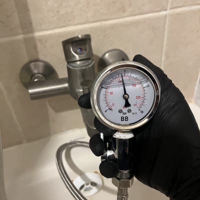 מד לחץ מים מחובר לברז לבדיקה