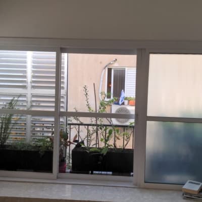 חלון זכוכית נקי עם צמחים בעציצים לידו