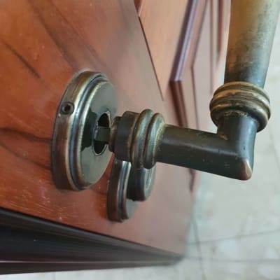 ידית דלת מתכתית על דלת עץ