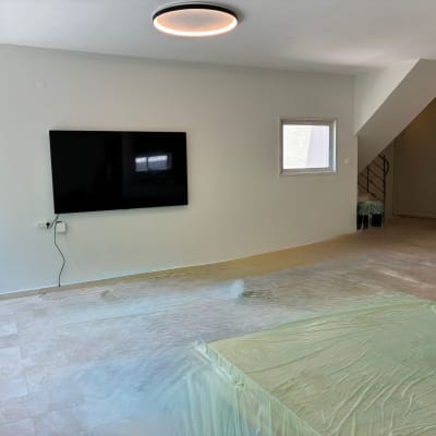 חדר עם קיר צבוע וטלוויזיה תלויה