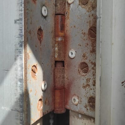 ציר חלוד של תריס מתכת עם ברגים