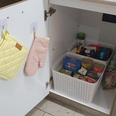 ארון מטבח פתוח עם סלסלות אחסון ומוצרי מזון