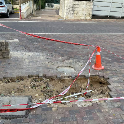 אזור חפירה בכביש עם קונוס וסרט סימון