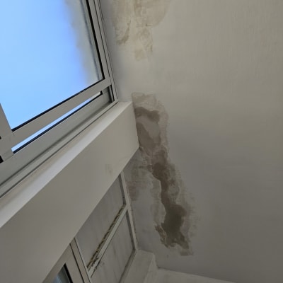 תריסים סגורים ליד חלון עם קיר מתקלף