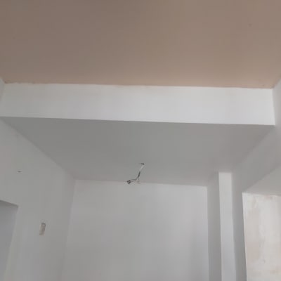 קיר גבס לבן עם תקרה צבועה וחוטי חשמל חשופים