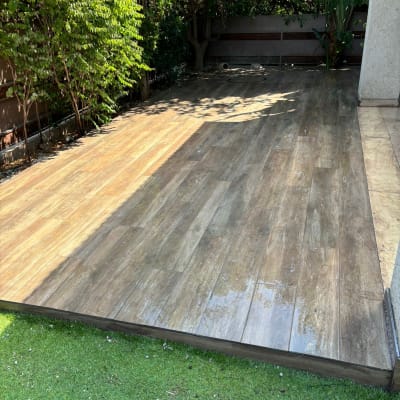 רצפת דק עץ חדשה בגינה עם דשא סינתטי