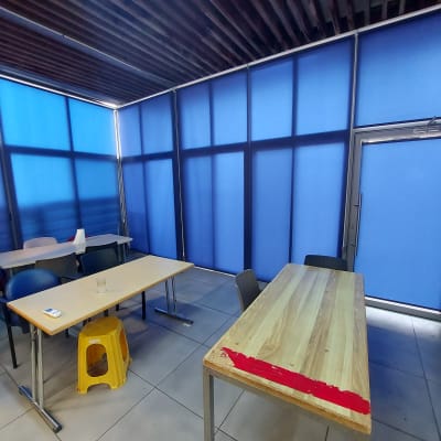 וילונות כחולים מכסים חלונות ודלת בחדר.