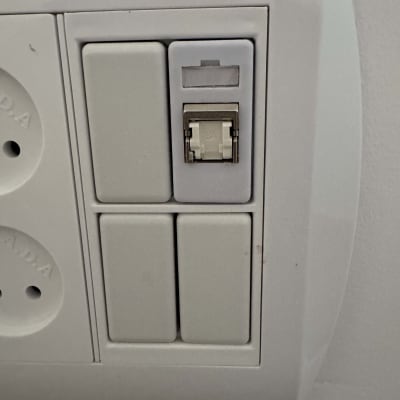 שקע רשת תקשורת RJ45 מותקן בקיר לצד שקעי חשמל