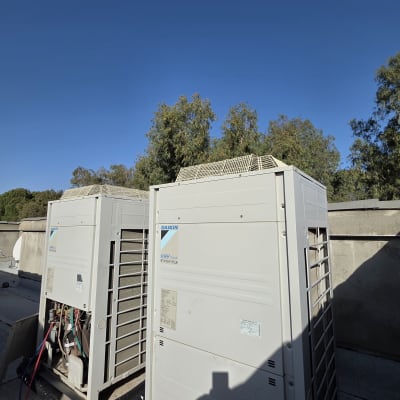 יחידות מיזוג אוויר על גג עם שמיים כחולים ברקע