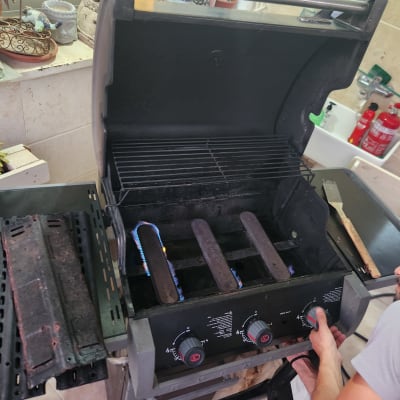 אדם מכוון כפתור על גריל גז פתוח