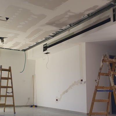 תקרת גבס בתהליך התקנה עם סולמות וכלים