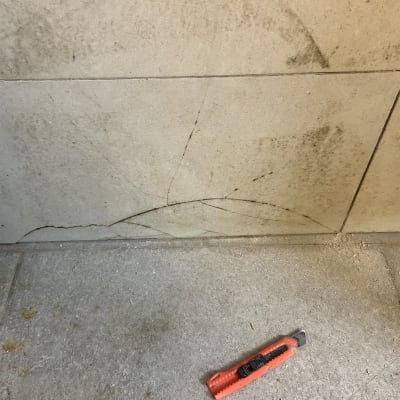 אריחים סדוקים עם סכין חיתוך על הרצפה