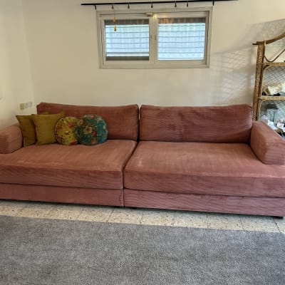 ספה ורודה עם כריות צבעוניות בחדר מגורים