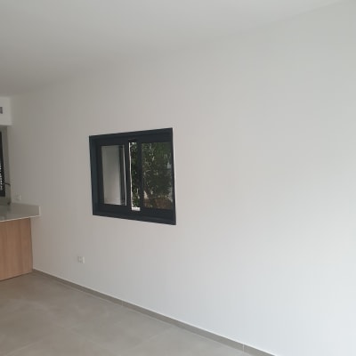 קיר צבוע בלבן עם חלון שחור