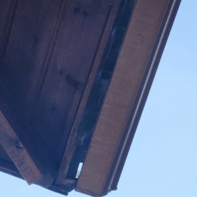 גג עץ עם קורות ותמיכה מתחת לשמיים בהירים