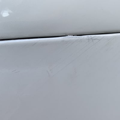 שריטות על דלת רכב לבנה עם פאנל שחור