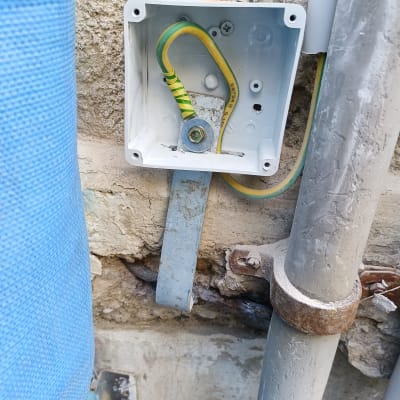 תיבת חיבורים עם חוטי חשמל וקיר חיצוני