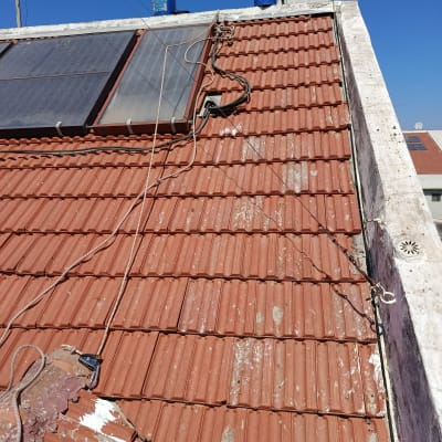 עבודת תיקון ואיטום בגג רעפים עם חבלי אבטחה לעבודה בגובה