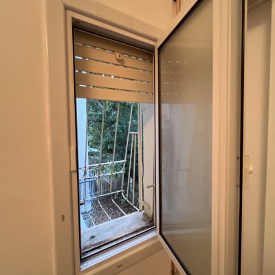 חלון פתוח עם תריסים, נוף חיצוני