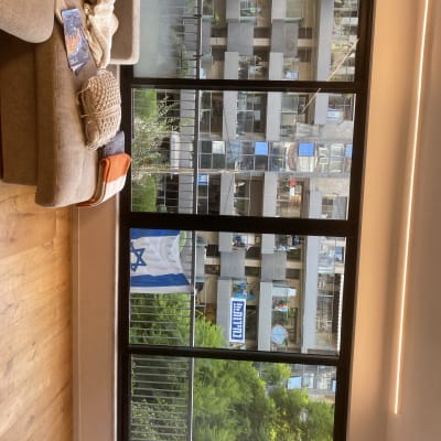 ספה עם כריות ושמיכה, חלון גדול עם נוף חיצוני