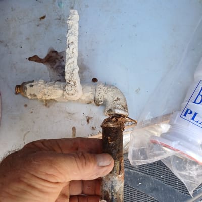 יד מחזיקה צינור חלוד עם ברז ישן