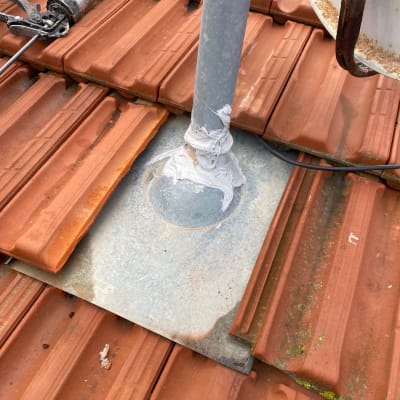 צינור מתכת עם איטום על גג רעפים אדום