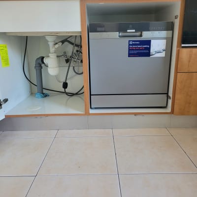 כיור מטבח עם צנרת מתחת לארון פתוח